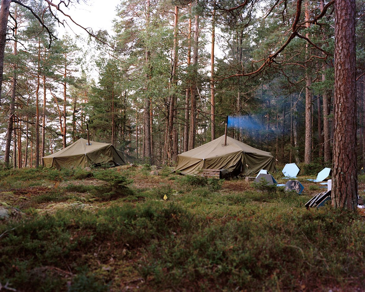 Camp tents in the pine forest with hexagonal panels laid on the ground, Borgåsen