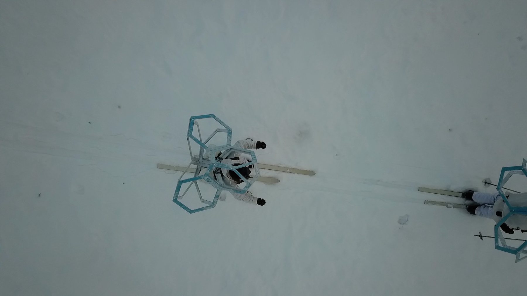 Skier towing a hexagonal panel form across the tundra, Rendalen