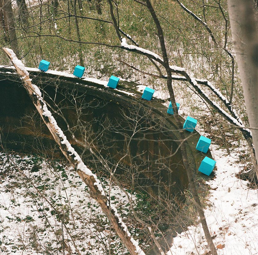 Marker line along a moss-covered concrete ruin in the snowy forest, Togatta